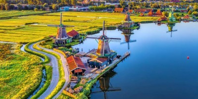 Zaanse Schans windmills park and fields landscape in Zaandam near Amsterdam, North Holland, Netherlands, aerial view in sunrise light.